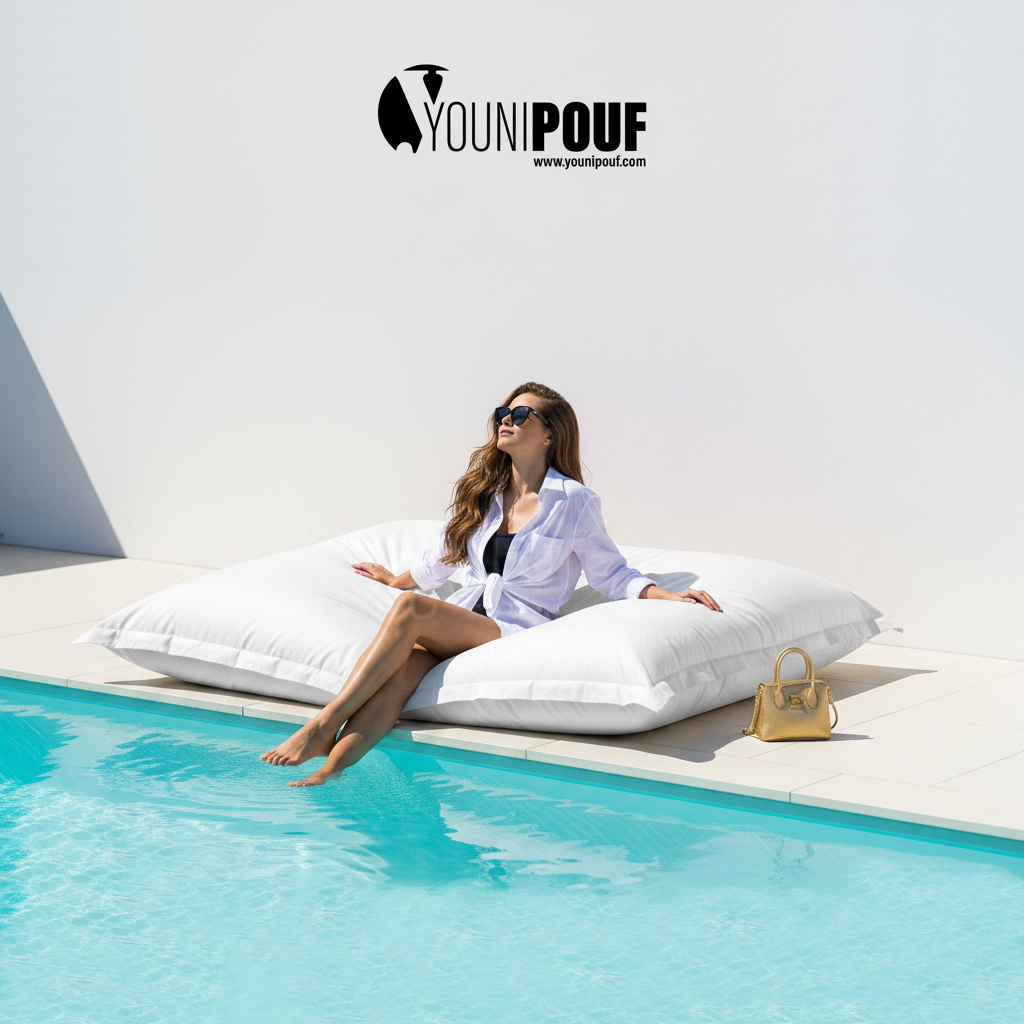 Pouf géant outdoor blanc au bord d’une piscine, mobilier détente YOUNIPOUF pour terrasse et jardin.